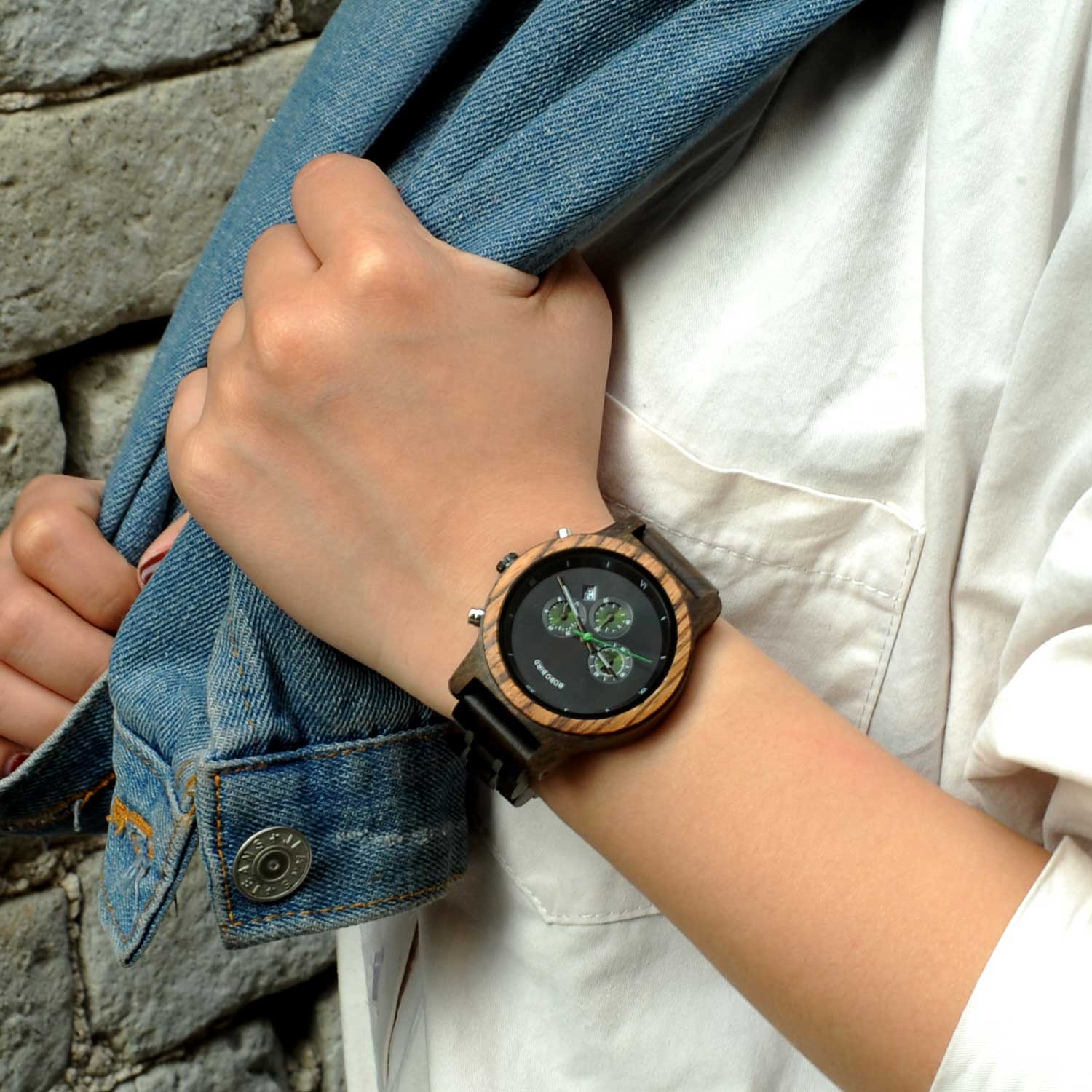 Montre en bois_Aurore_noir au poignet d'une femme qui porte sa veste en nature