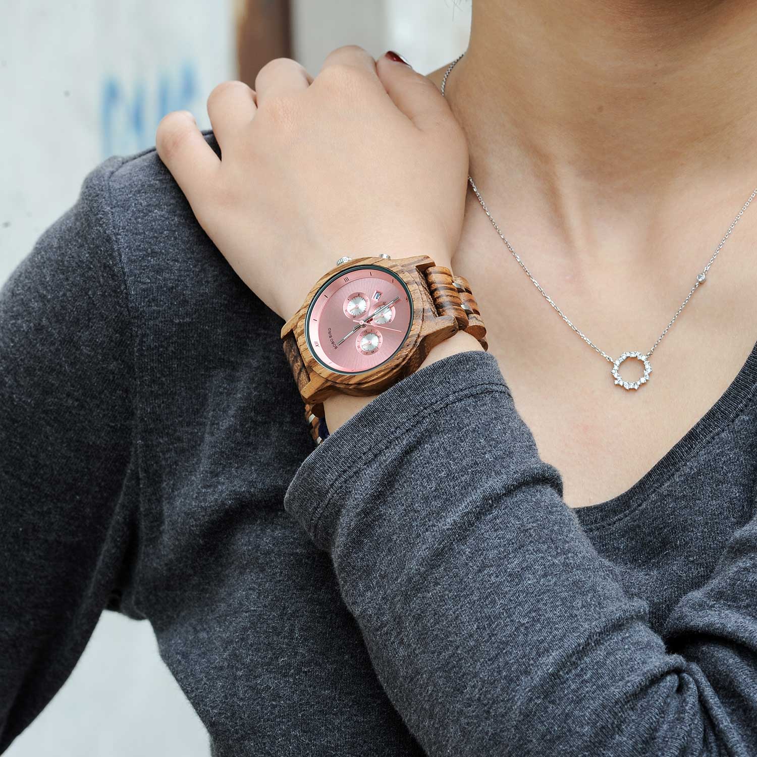 Montre en bois_Aurore rose sur le poignet d'une femme 
