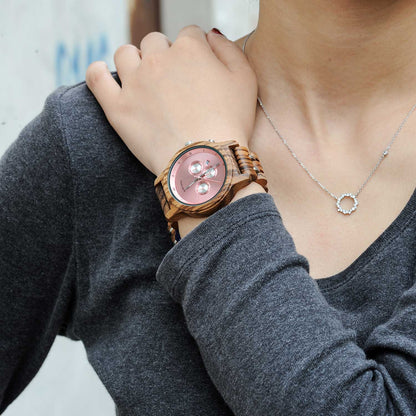 Montre en bois_Aurore rose sur le poignet d'une femme 