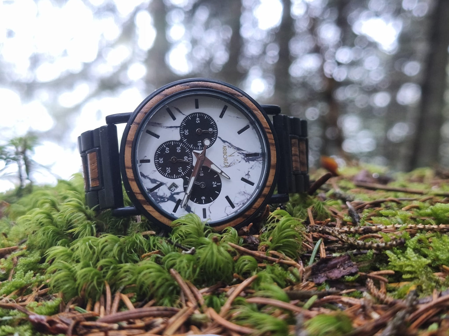 Montre_en_bois_Origine sur un tapis de mousse vert en pleine nature